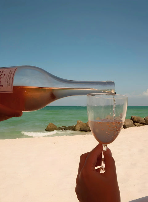 Sirviendo vino rosado en la playa