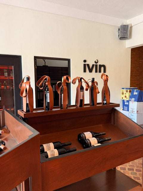 Mostrador de la tienda IVIN con portabotellas de cuero y el letrero ivin en la pared
