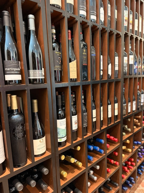 Muro de madera con botellas de vino tinto en la tienda IVIN